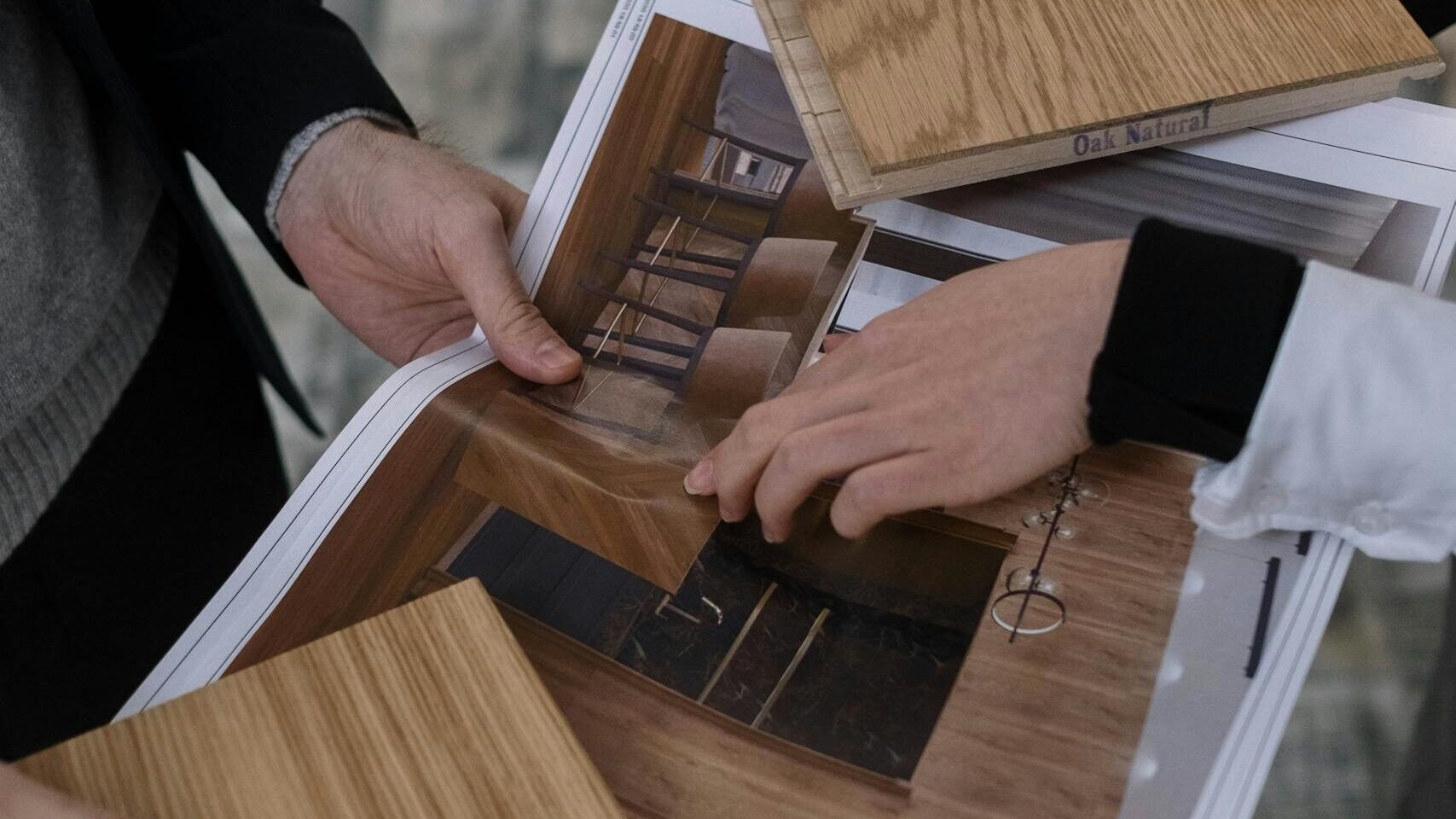 Group of architects reviewing interior design plans and wood samples for a new project.
